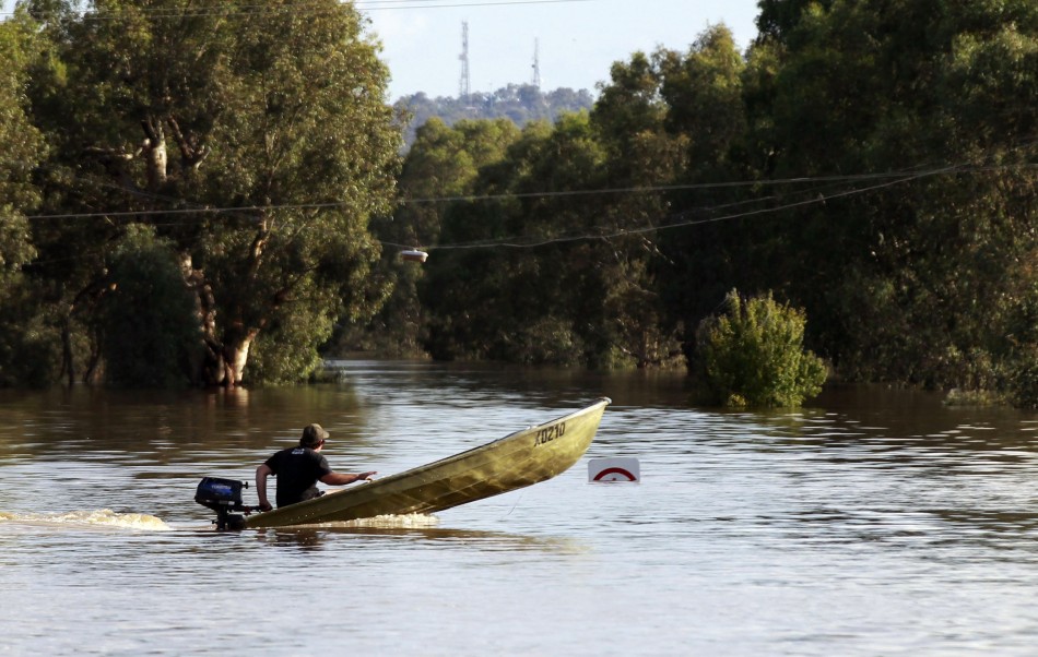 A man drives a boat on a road submerged in flood waters near Wagga Wagga