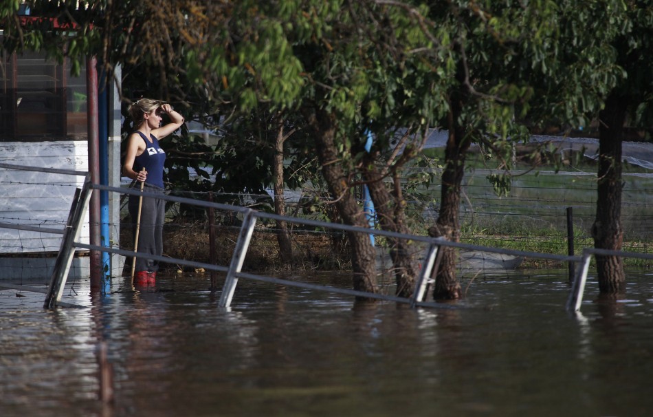 A woman looks out from her house surrounded by flood waters in Wagga Wagga
