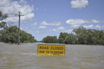 A flood warning sign starts to disappear below floodwaters near Charleville