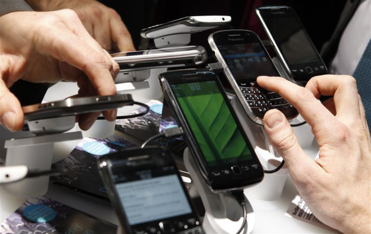 Visitors inspect Blackberry mobile phones at their booth at the CeBit computer fair in Hanover