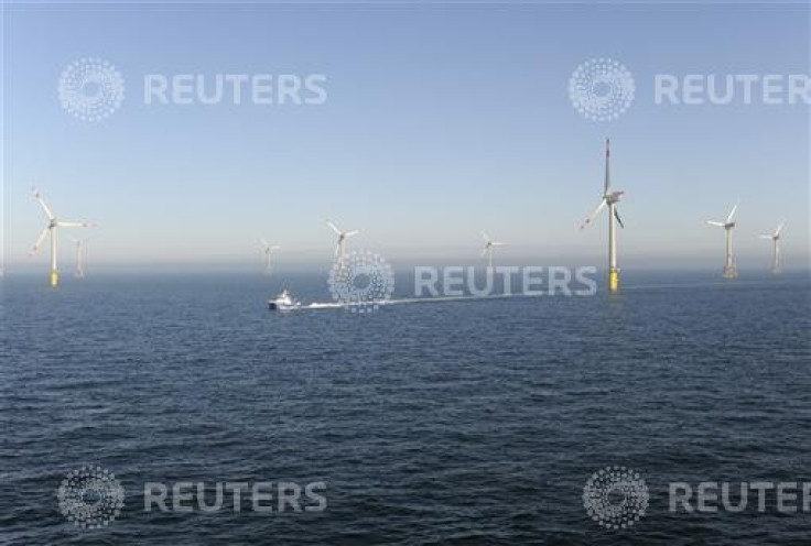 A service vessel passes next to wind energy plants in the offshore energy park Alpha Ventus in the North Sea