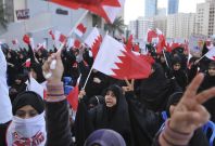 Bahraini protesters hold national flags during a demonstration outside the United Nations headquarters in Manama