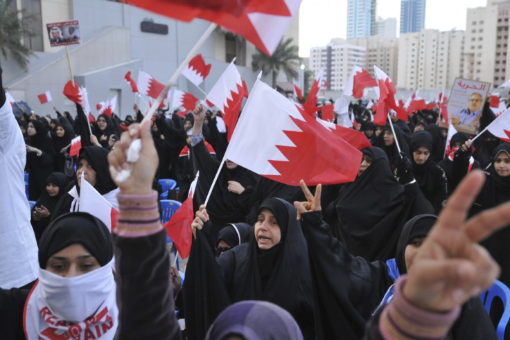 Bahraini protesters hold national flags during a demonstration outside the United Nations headquarters in Manama