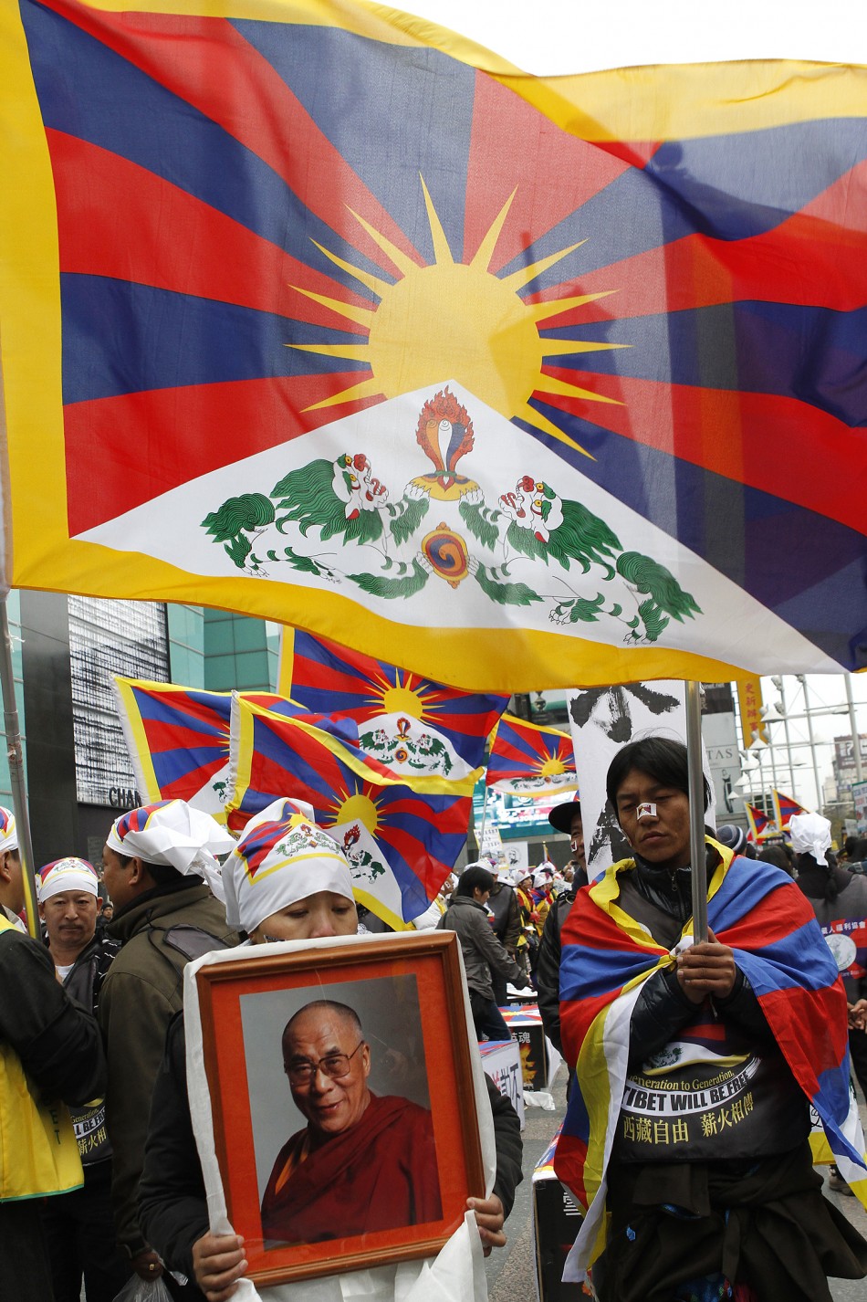 Activists holding a picture of the Dalai Lama and the Tibetan flags take part in a rally to support Tibet in Taipei