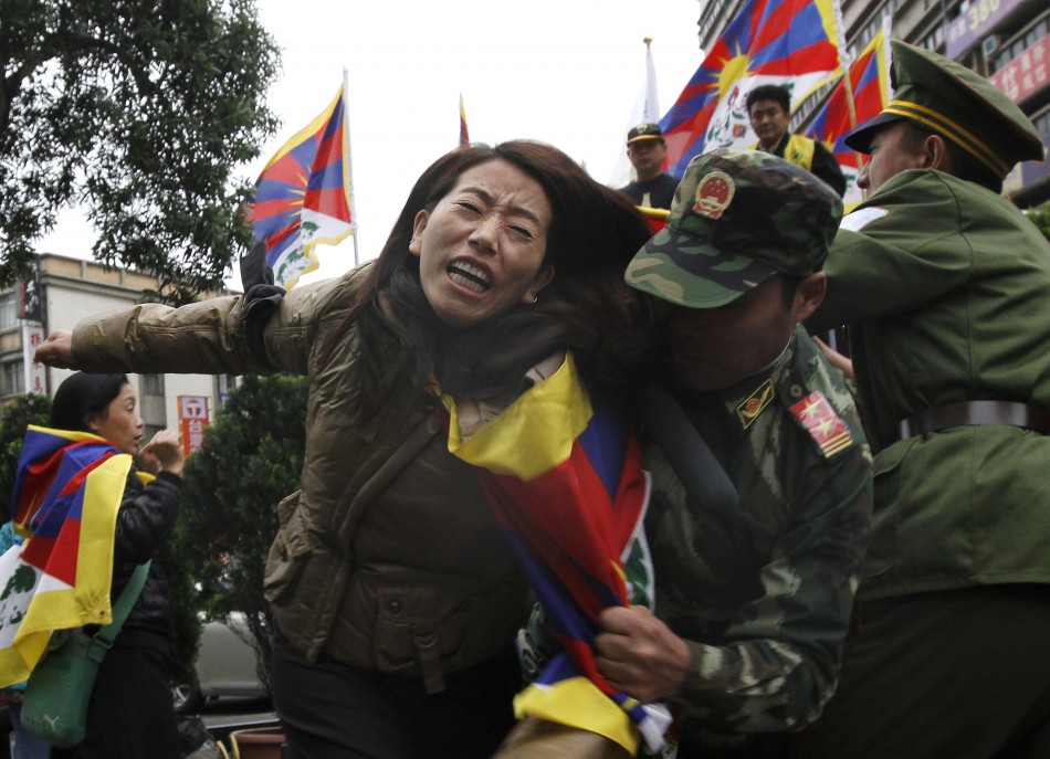 Activists dressed as Chinese soldiers and a Tibetan perform a street drama