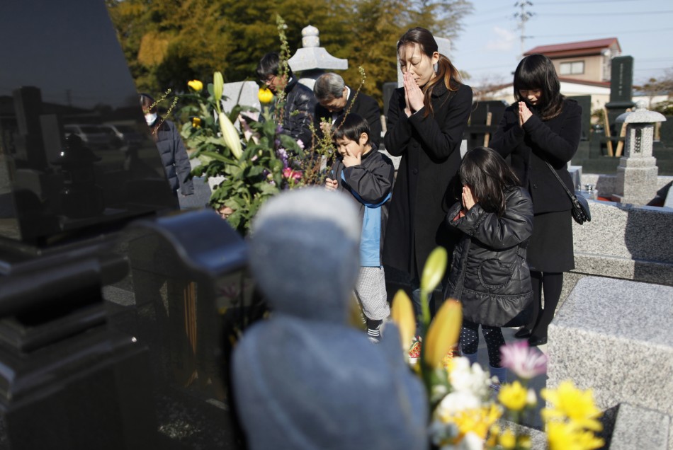 The family of a man who was killed by the tsunami observes a moment of silence at 246 p.m. in Higashimatsushima