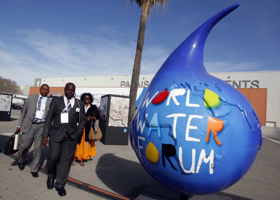 Participants walk past the logo of the 6th World Water Forum in Marseille