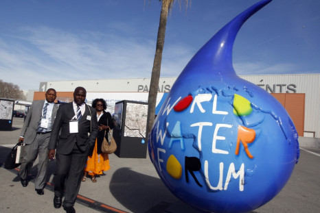 Participants walk past the logo of the 6th World Water Forum in Marseille