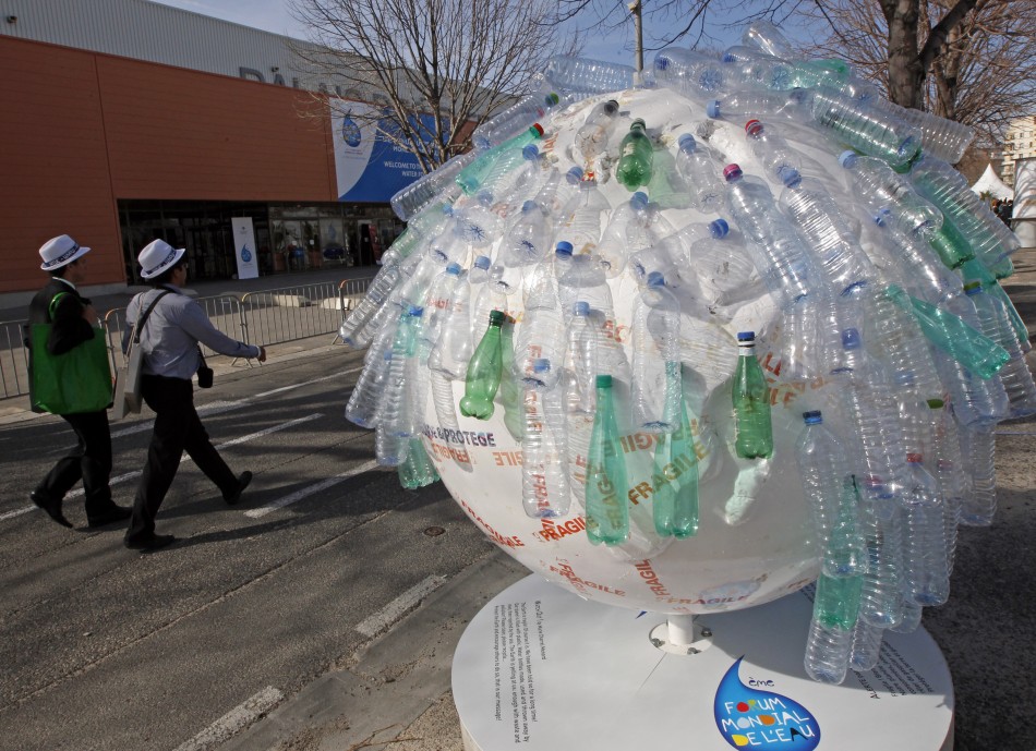 Participants walk past a globe decorated with plastic water bottles at the 6th World Water Forum in Marseille