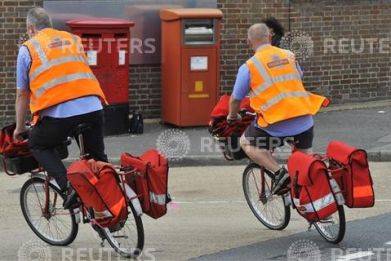 Postal workers return to a delivery office in west London