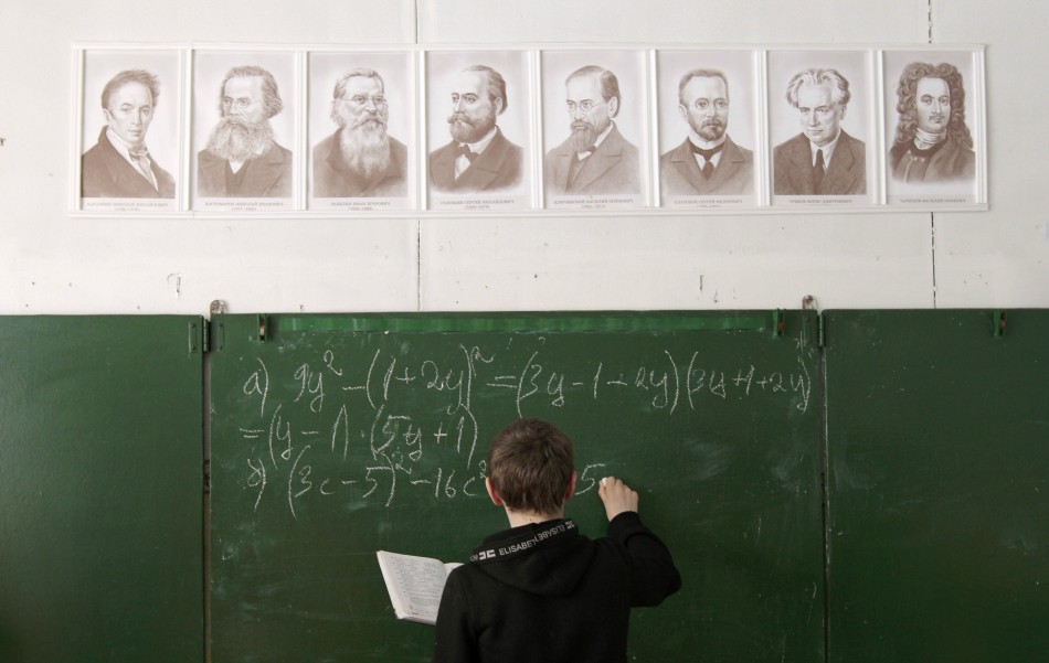 A pupil writes on the blackboard as he attends a mathematics lesson at a local school based in the remote Russian village of Bolshie Khutora