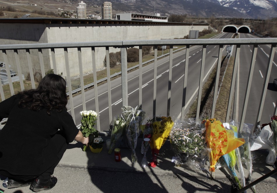 Woman places floral tributes on walkway in front of the Tunnel de Sierre following a bus crash in Sierre