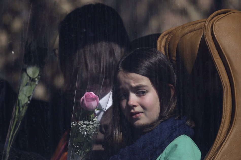 A girl holds rose while waiting in bus to visit the scene of accident at Tunnel de Sierre in Uvrier