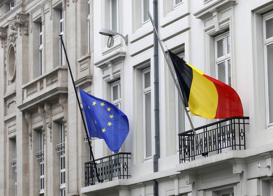 A European Union flag and a Belgian flag fly at half mast outside an official government building in Brussels