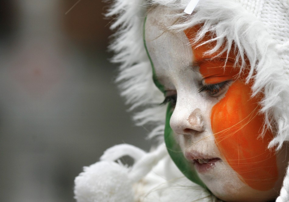 A girl with face paint in Irish national colours looks on during the Saint Patricks Day parade along Dublins city centre