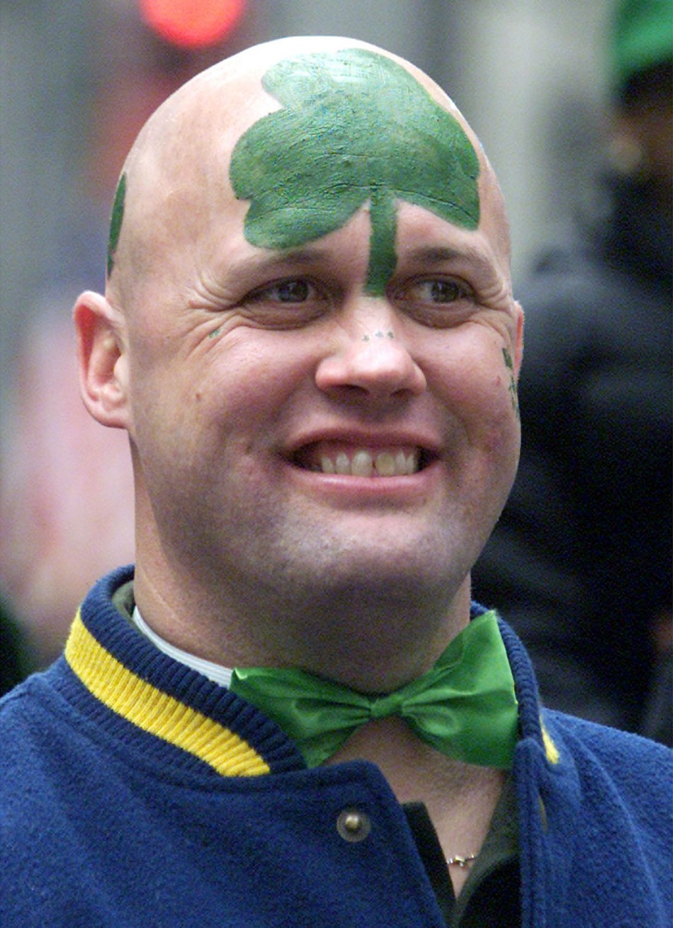 MAN WITH PAINTED HEAD WATCHES SAINT PATRICKS DAY PARADE IN NEW YORK.