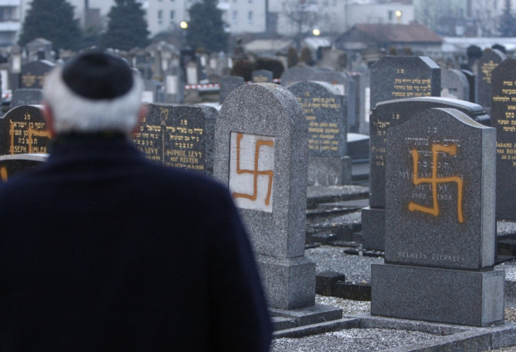 Francis Levy, head of the North Alsacian Jewish community, inspects desecrated tombstone in the Jewish Cemetery of Cronenbourg near Strasbourg,
