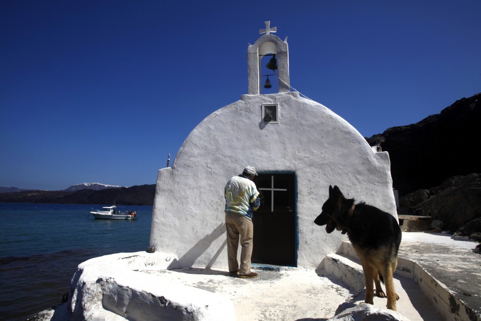 Sostis enters the Saint Nicolas church on the volcanic islet of Palaia Kameni located in the caldera of Santorini