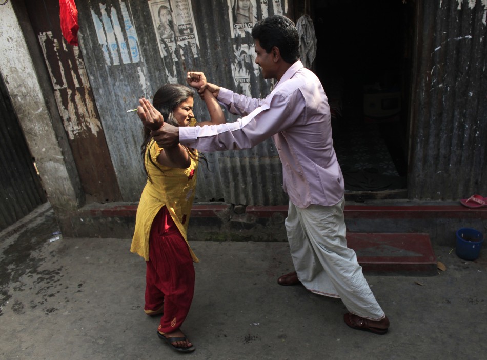 A customer jokes with seventeen-year-old prostitute Hashi as she tries to grab him into her room at Kandapara brothel in Tangail, a northeastern city of Bangladesh