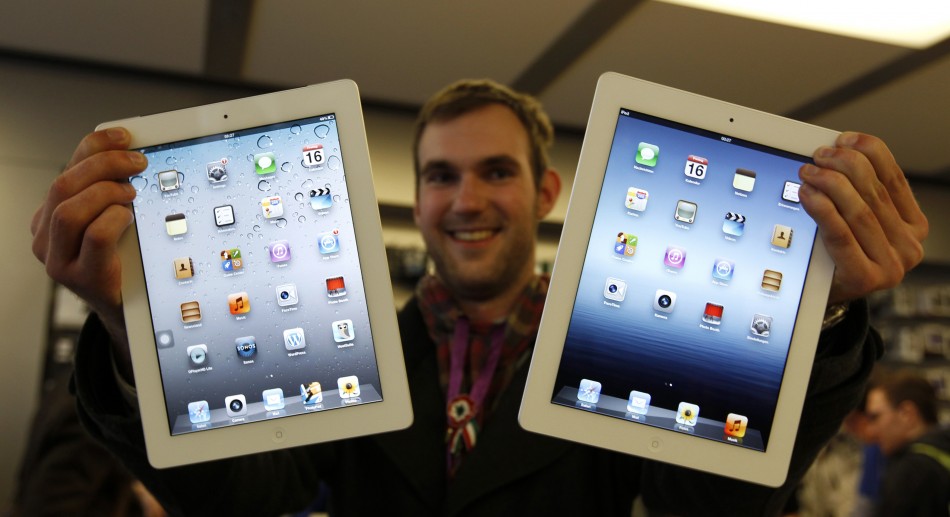 Balazs Gal, one of the first new iPad buyers in Germany, poses with a new iPad and an iPad2 in the Apple store in Munich