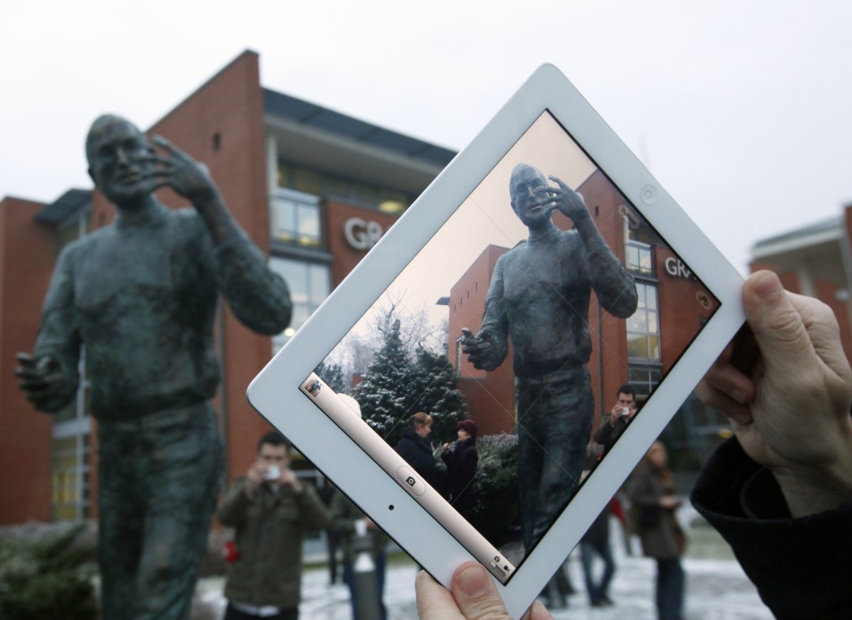 A man takes pictures with his iPad during the unveiling ceremony of a statue of Steve Jobs at a private business park in Budapest