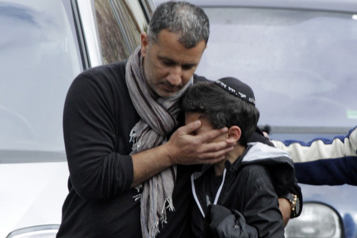 A school student is escorted as he leaves the Ozar Hatora Jewish school in Toulouse, southwestern France