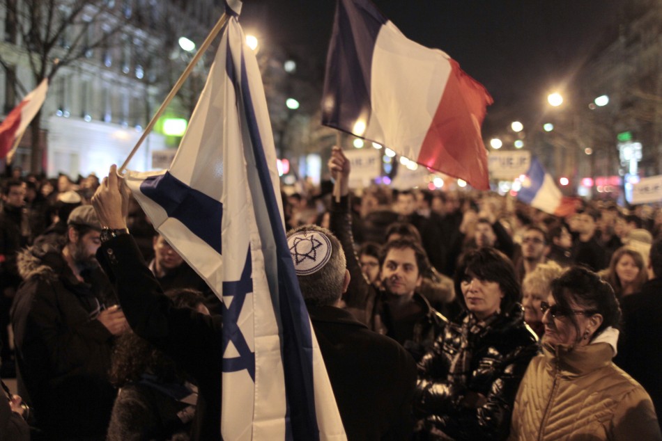 People hold French and Israeli flags