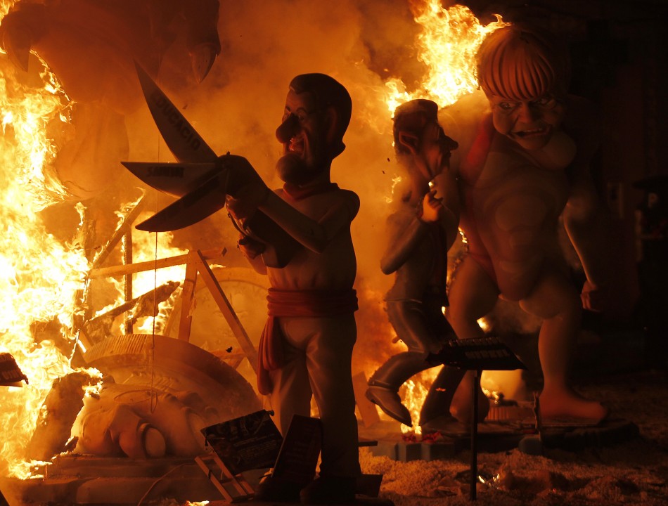 Effigies of Spains Prime Minister Rajoy and German Chancellor Merkel burn during the finale of the Fallas festival in Valencia