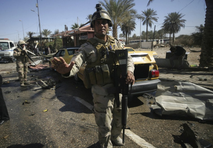 Iraqi security forces stand guard at site of bomb attack in Kerbala