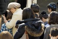 A teacher comforts a school child as they observe a minute of silence at a Jewish school in Paris