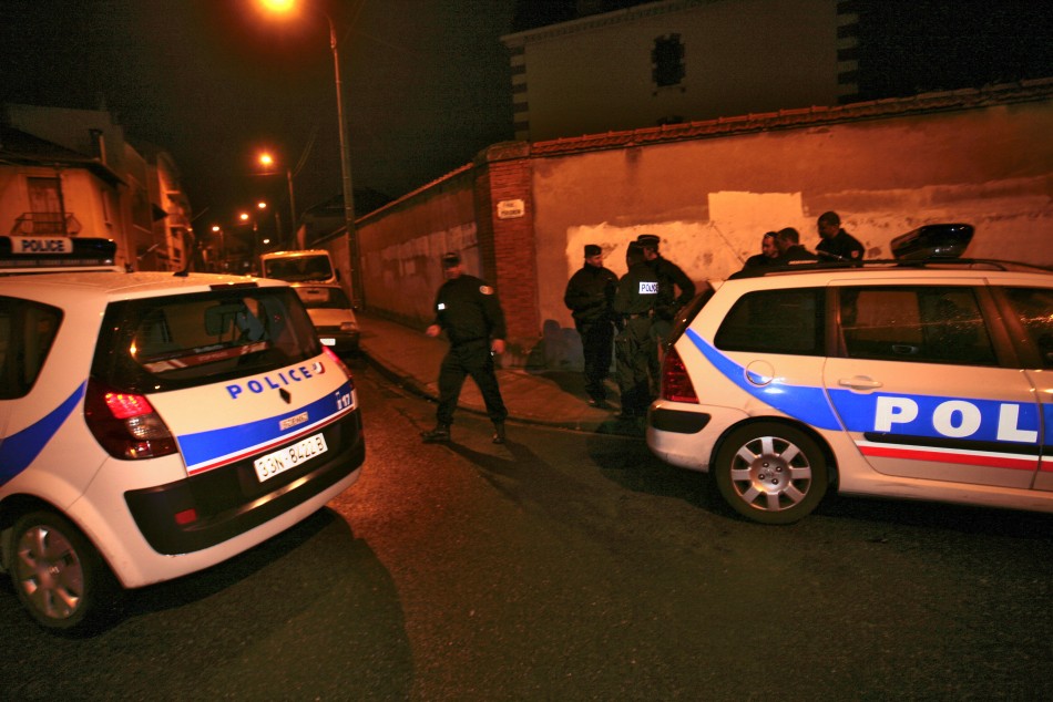 Policemen block streets as a raid on a house to arrest suspects in the killings of three children and a rabbi on Monday
