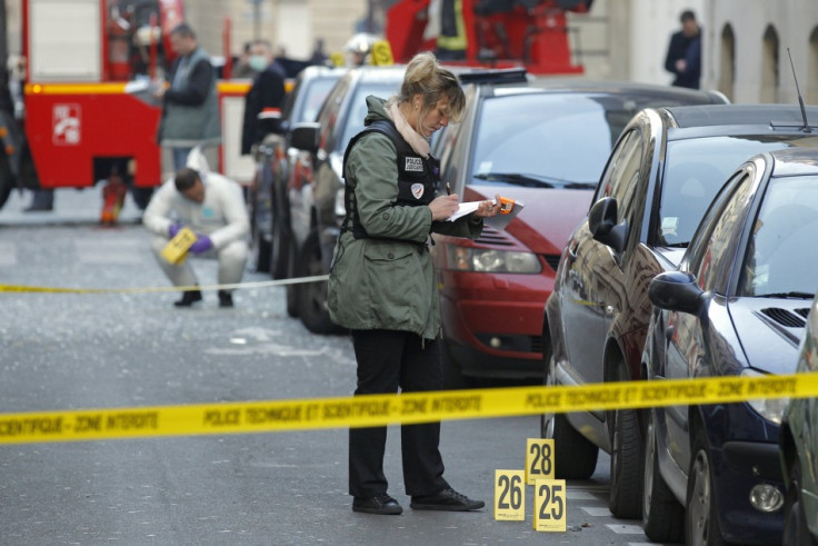 Police conduct thier investigaton near the Indonesian embassy where a package bomb exploded in Paris