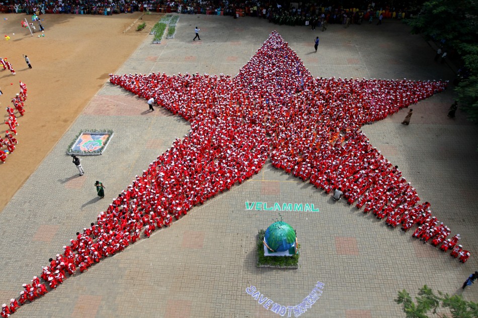 Schoolchildren dressed as Santa Claus form the shape of a star