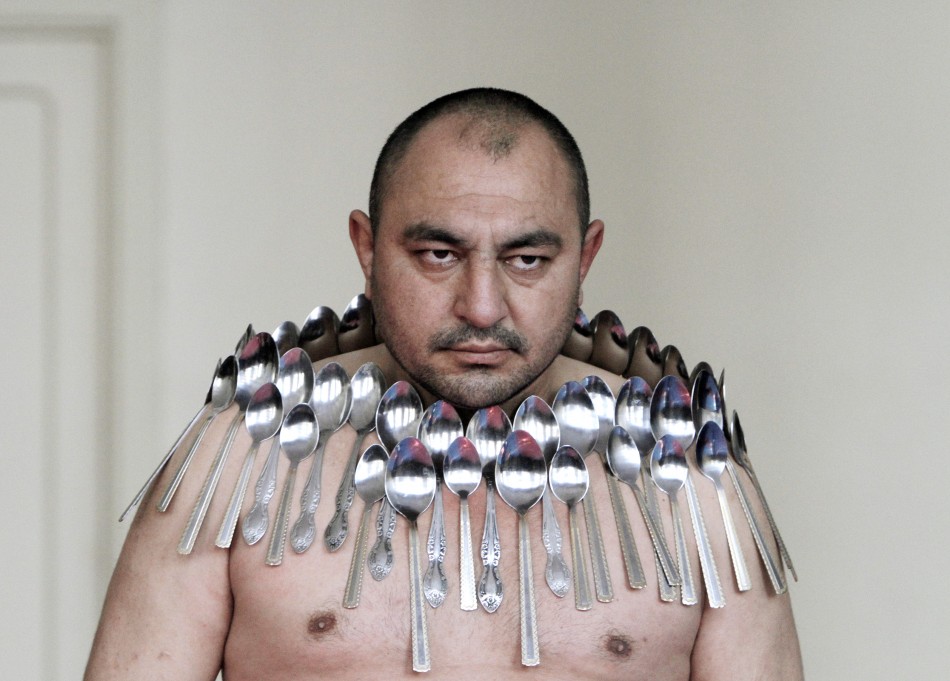Etibar Elchiyev poses with 50 metal spoons