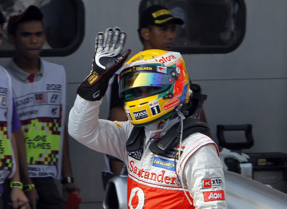 McLaren Formula One driver Hamilton waves after taking the pole position in the qualifying session of the Malaysian F1 Grand Prix at Sepang International Circuit outside Kuala Lumpur