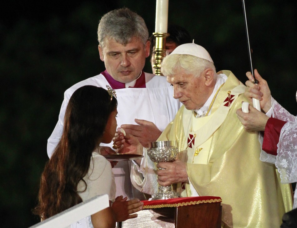 A girl receives communion from Pope Benedict XVI