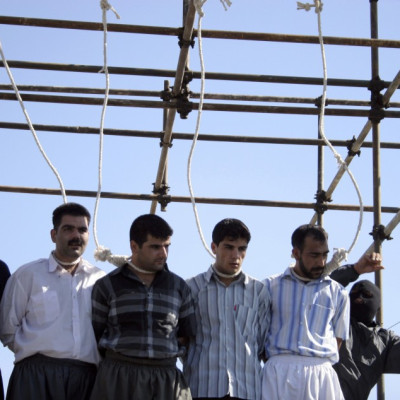 A policeman prepares five men for their hanging in Mashhad