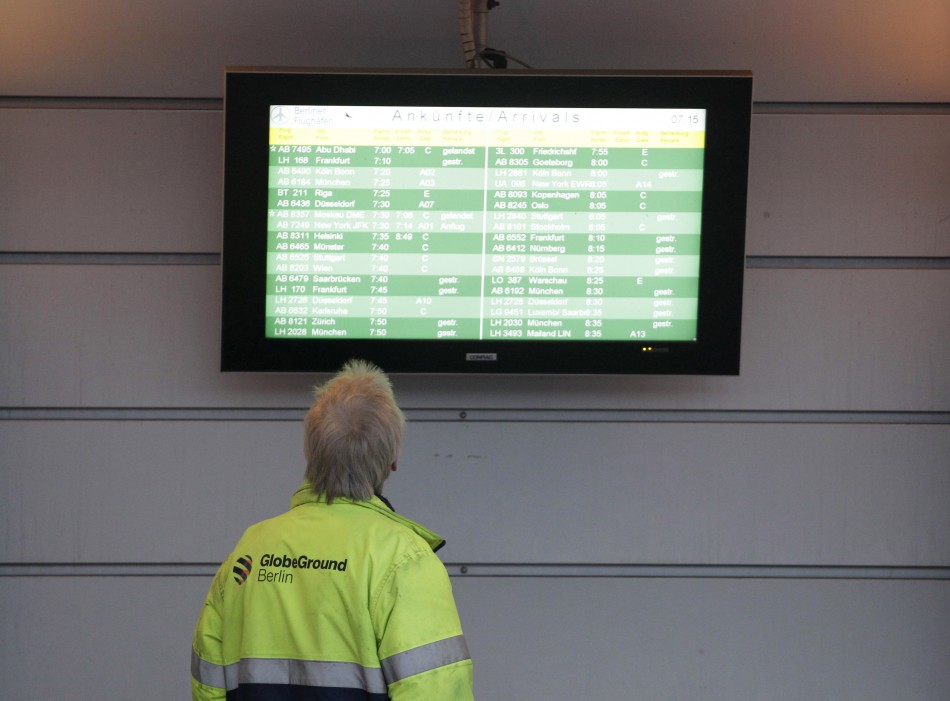 A worker looks at an arrival information board