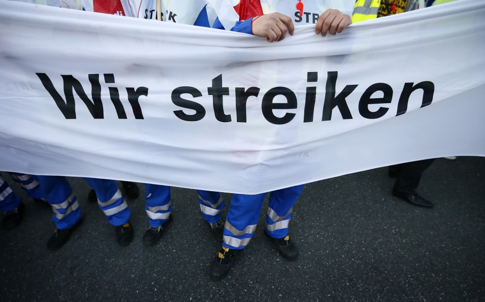 Members of Germanys public sector workers union Verdi hold a banner