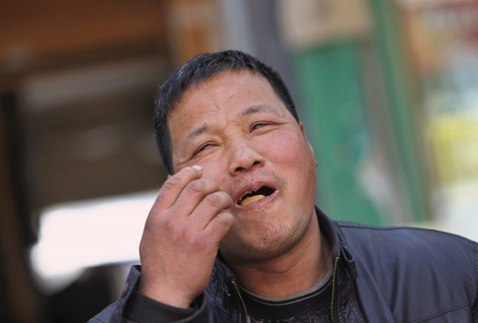 Vendor Ge Yaohua eats a hard-boiled egg cooked in boys urine at his stall in Dongyang