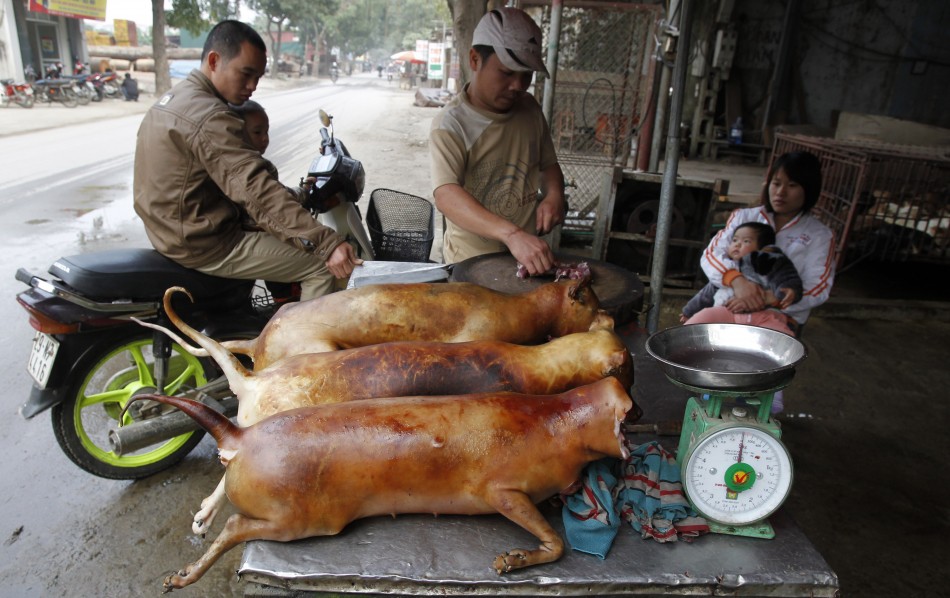 A vendor cuts slaughtered dogs for sale at his roadside stall in Duong Noi village, outside Hanoi