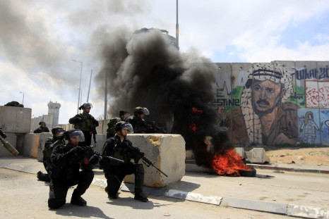 Israeli soldiers take position during clashes with Palestinian protesters at a demonstration marking Land Day at Qalandiya checkpoint