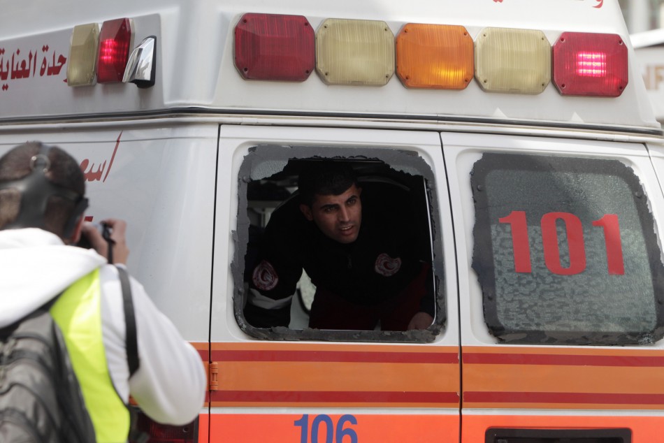 A medic looks through a broken ambulance car window during clashes at a demonstration marking Land Day at Qalandiya checkpoint
