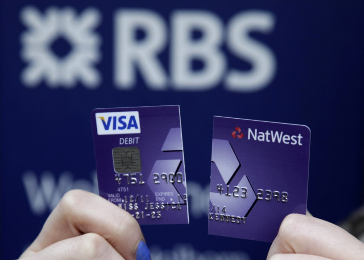 RBS-NatWest customer holds up debit card cut in half to demonstrate dissatisfaction with service following computer glitch