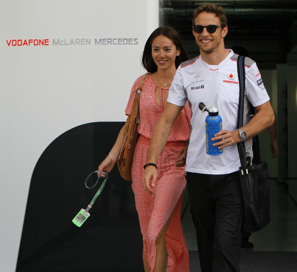 McLarens driver Button and his girlfriend, Jessica Michibata, walk in the paddock area after the qualifying session of the Malaysian F1 Grand Prix at Sepang International Circuit