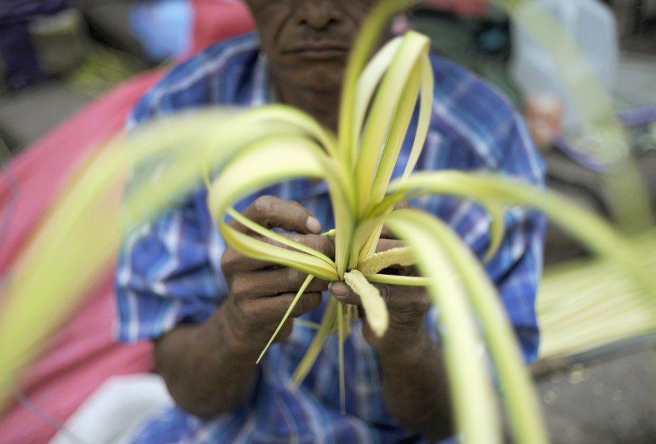 A man works a palm branch for sale outside a church in Tegucigalpa