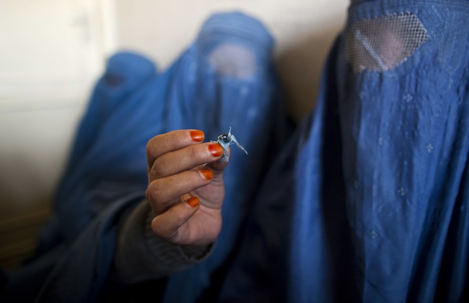 An Afghan woman holds up opium as she attends a counseling session at the Nejat drug rehabilitation centre, an organisation funded by the United Nations providing harm reduction and HIVAIDS awareness, in Kabul