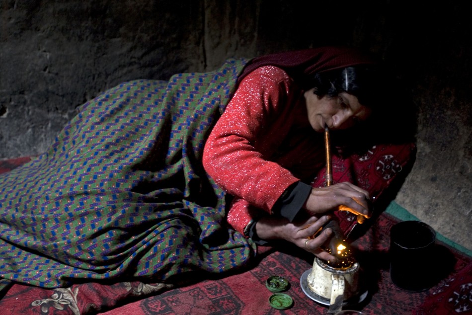 Naik Bakhat, a 35-year-old mother of four, smokes opium in her house in the Eshkashem district of Badakhshan province, northeast of Kabul April 24, 2008.