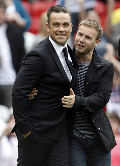 British singer Robbie Williams L walks onto the pitch with band mate Gary Barlow British singer Robbie Williams L walks onto the pitch with band mate Gary Barlow