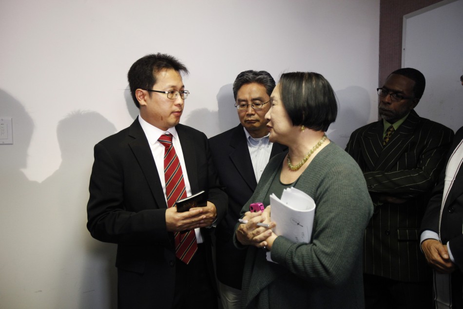 Hyok-in Kwon and Kyung Kim of the Korean United Methodist Church speaks to Oakland Mayor Jean Quan during a news conference after a shooting incident at Oikos University in Oakland